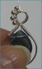 Judy Larson's Beaded Briolette Pendant - , Wire Weaving, Wire Wrapping, Wrapping, Wire Wrapping Jewelry, Weaving, Wire Weaving, Weaving Wire, Adding bead to the wire being wrapped around frame.